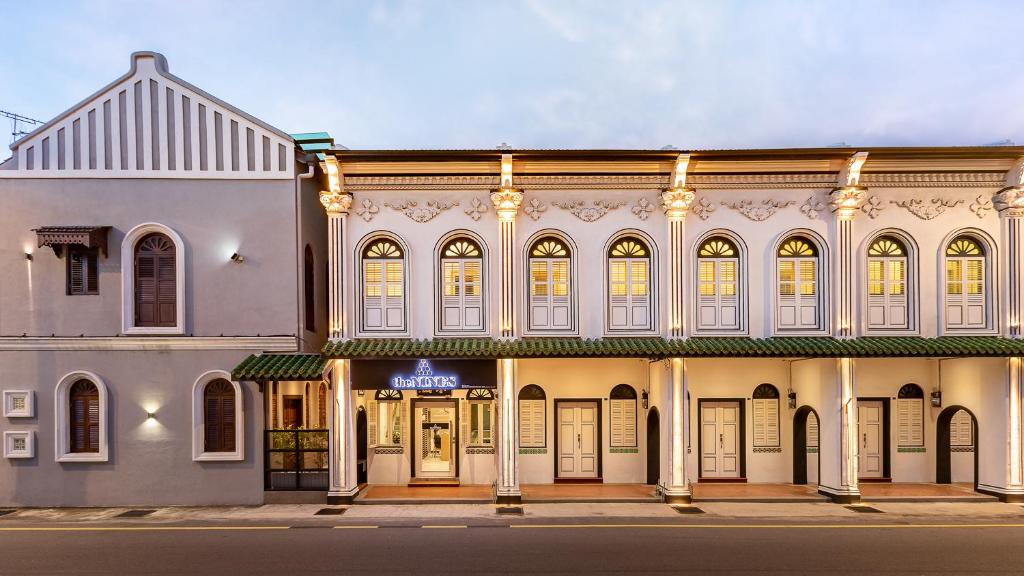 ein großes weißes Gebäude an einer Straßenecke in der Unterkunft The NINES HOTEL Malacca in Malakka