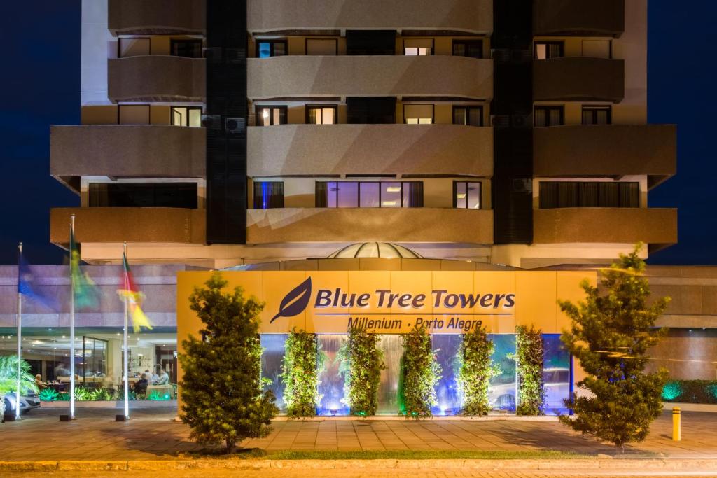 Blue Tree Towers Millenium Porto Alegre في بورتو أليغري: مبنى ابراج الاشجار الزرقاء امامه اشجار