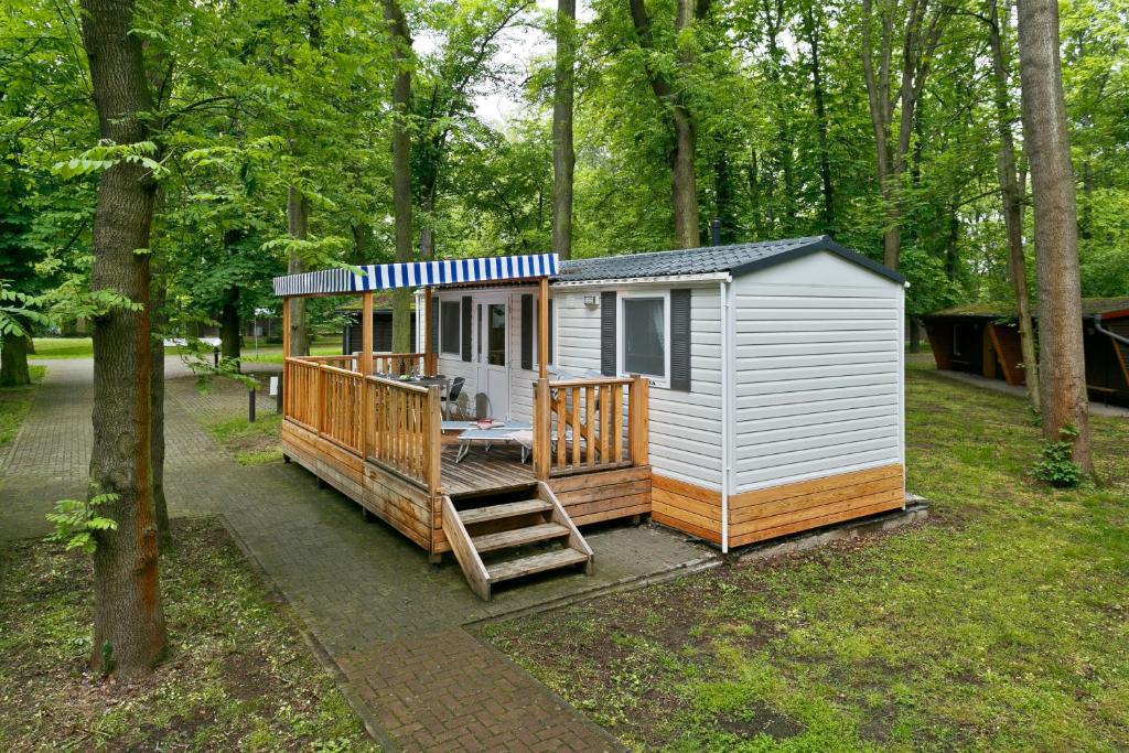 una casita en el bosque con porche en KNAUS Campingpark Hamburg, en Hamburgo