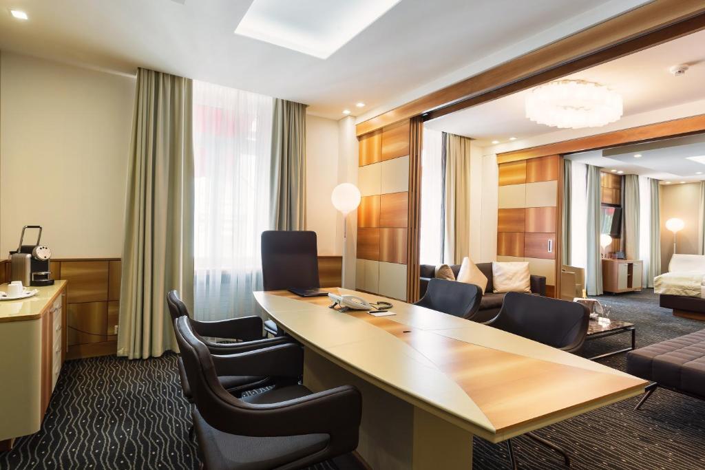 a hotel room with a desk and chairs at Hotel St.Gotthard in Zürich