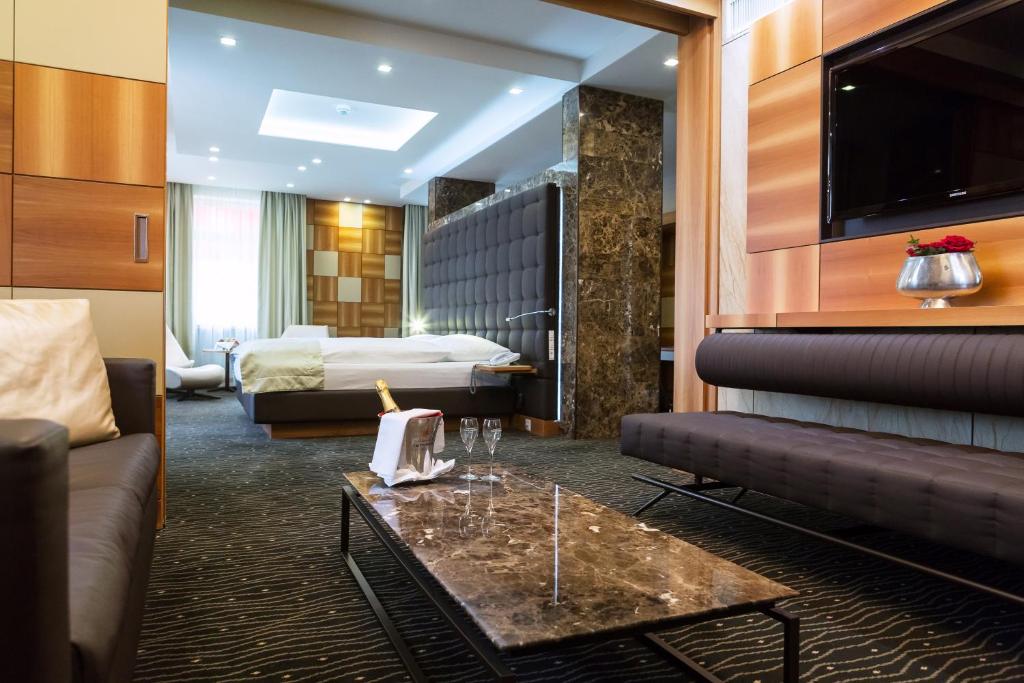 a hotel room with a bed and a couch and a table at Hotel St.Gotthard in Zürich