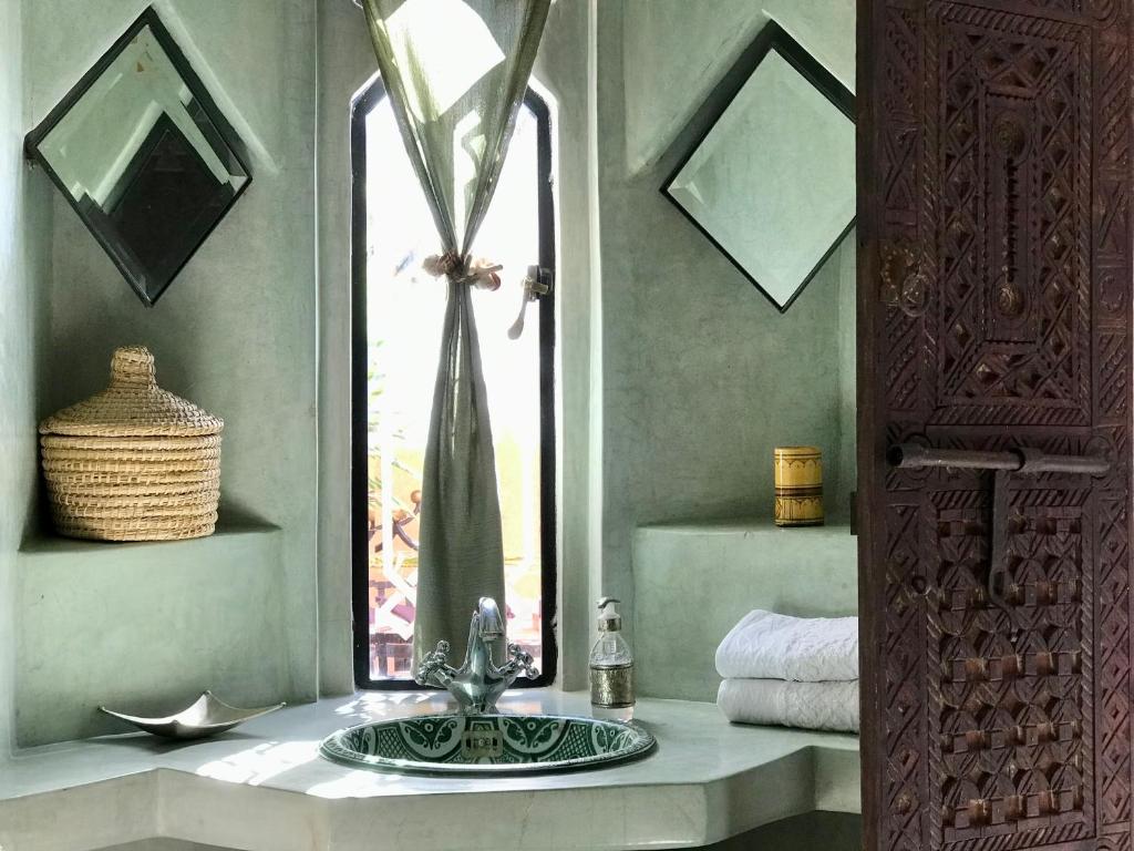 a bathroom with a sink and a window at Riad Zahir in Marrakech
