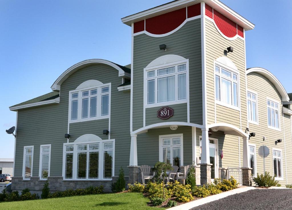 Casa grande con adornos rojos y blancos en Hotel La Porte de la Matawinie -Hôtel Matha, en Saint-Jean-de-Matha