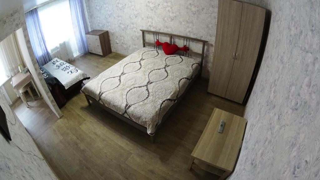 ノヴォシビルスクにあるАпартаменты на Блюхера 43のベッドルーム1室(赤い枕のベッド1台付)