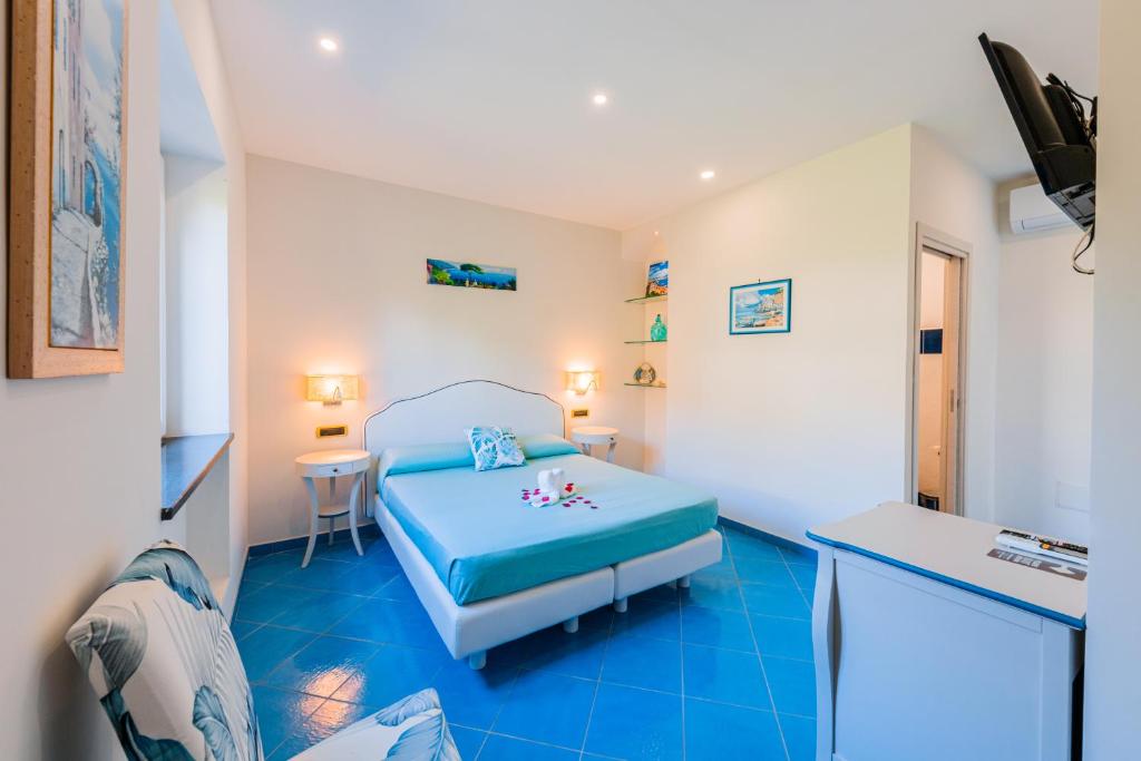 1 dormitorio con 1 cama y suelo azul en B&B il vetraio en Ravello