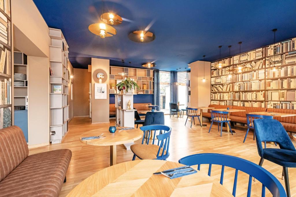 a restaurant with tables and chairs and bookshelves at Pension Zeitlos in Potsdam