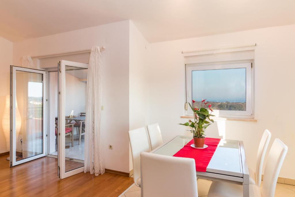 a dining room with a table and chairs and a window at SEA VIEW APARTMENT in Ližnjan