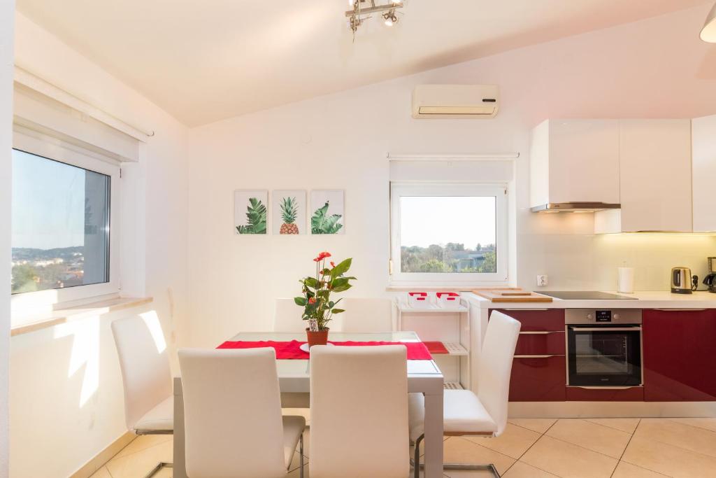 a kitchen and dining room with a table and chairs at SEA VIEW APARTMENT in Ližnjan