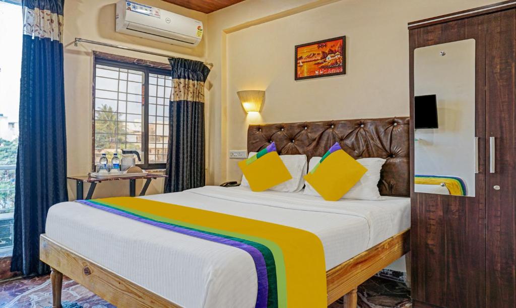 a bedroom with a large bed with yellow pillows at Itsy By Treebo - Punest in Pune