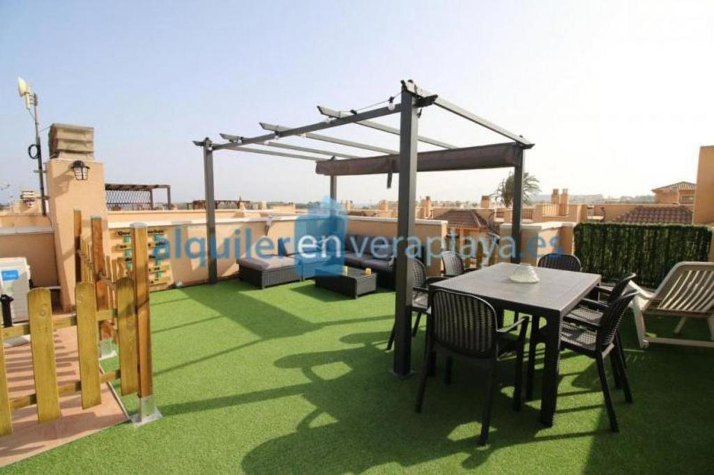 a patio with a table and chairs on a roof at La Union in Cuevas del Almanzora