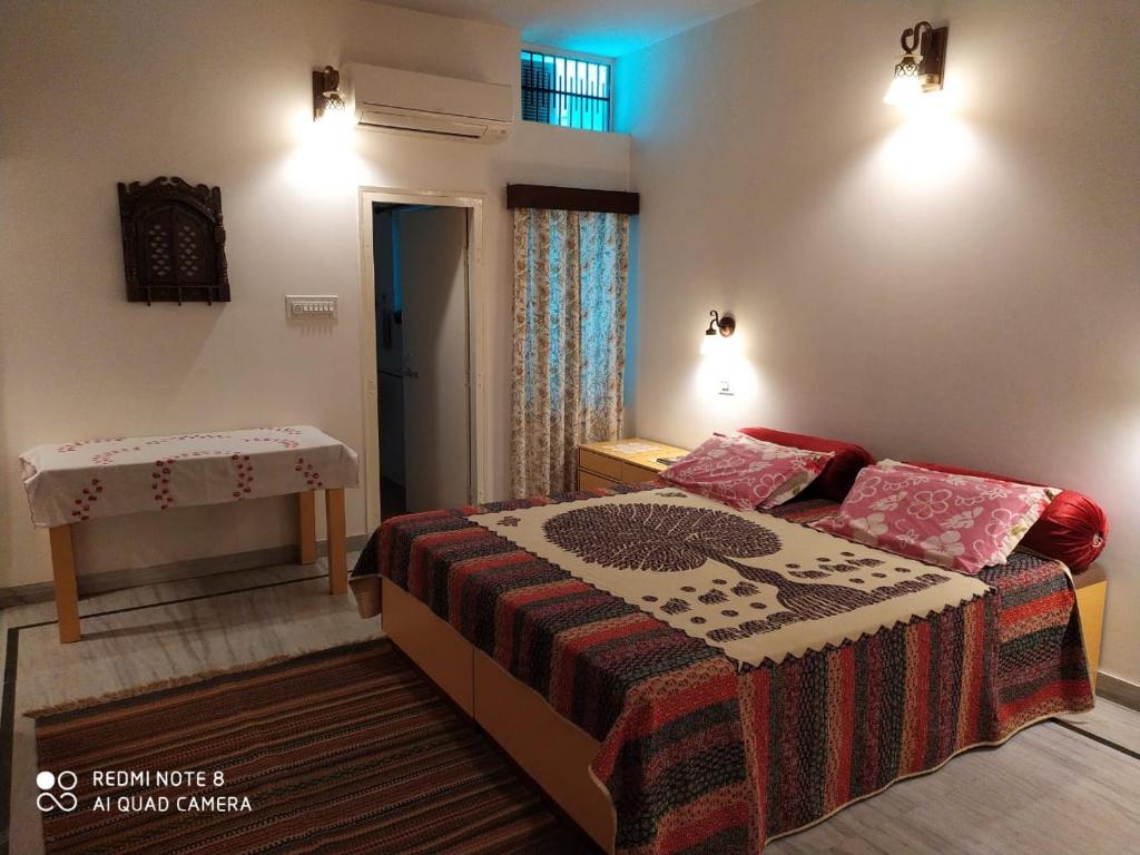 um pequeno quarto com uma cama e uma mesa em Happy Homestay em Jaipur