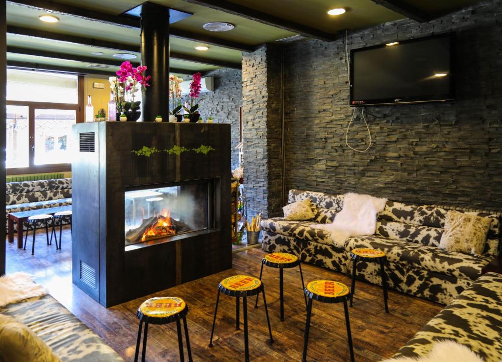 sala de estar con sofá y chimenea en Hotel Vall d´Aneu, en Esterri d'Àneu