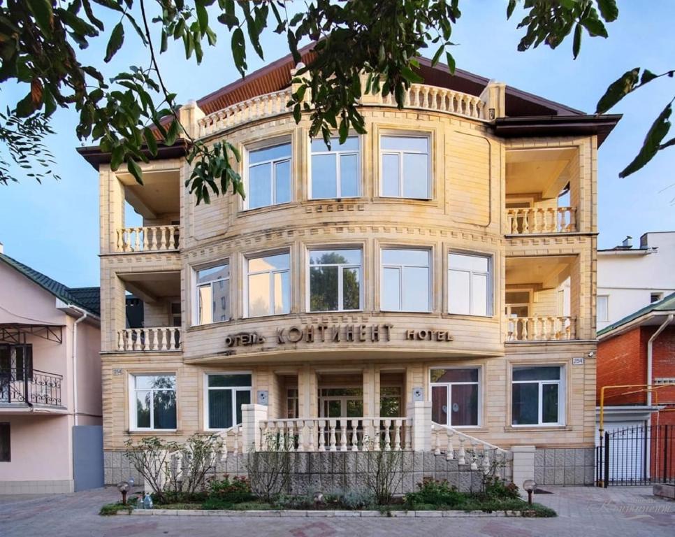 a large wooden building with a sign on it at Kontinent Hotel in Anapa