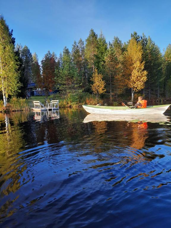 un barco sentado en el agua con dos sillas en Villa Latvus, en Rovaniemi
