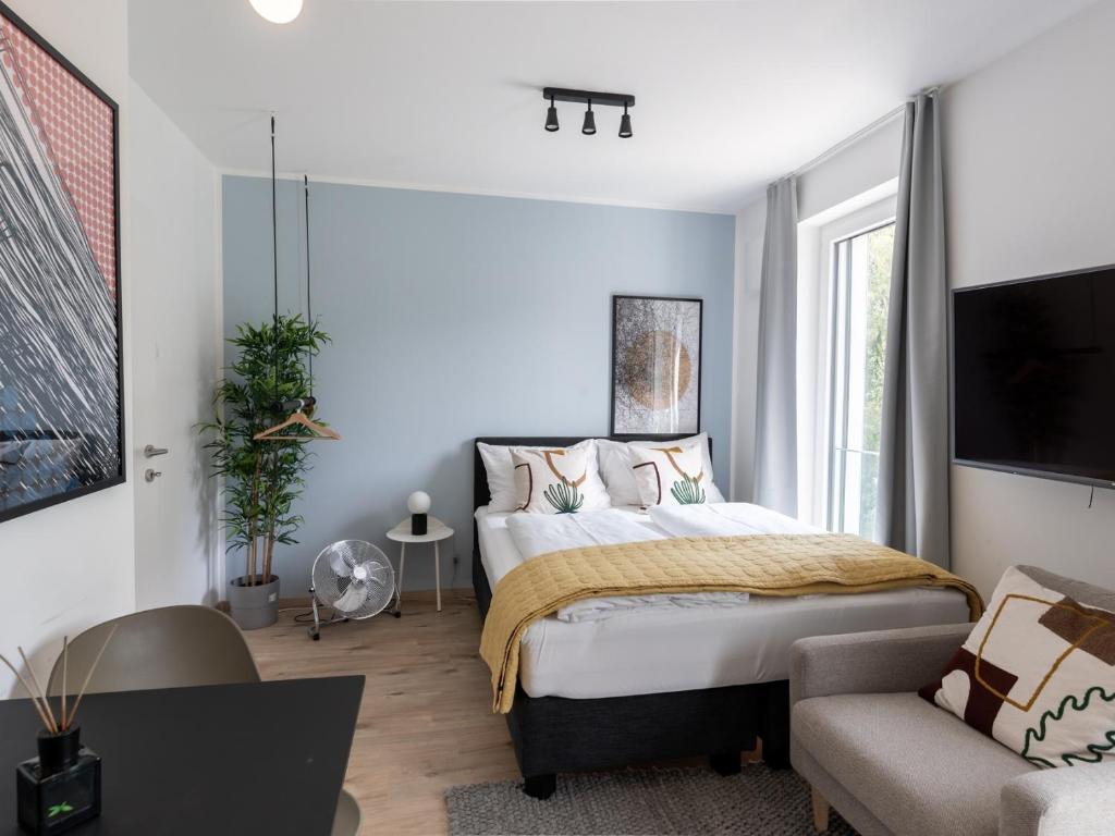1 dormitorio con 1 cama, TV y sofá en limehome Linz Hopfengasse en Linz