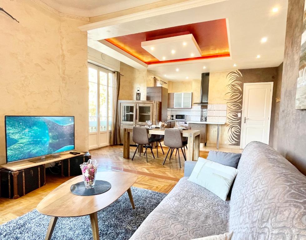 a living room with a couch and a tv and a table at Swiss Star - Easy Home Booking in Nice