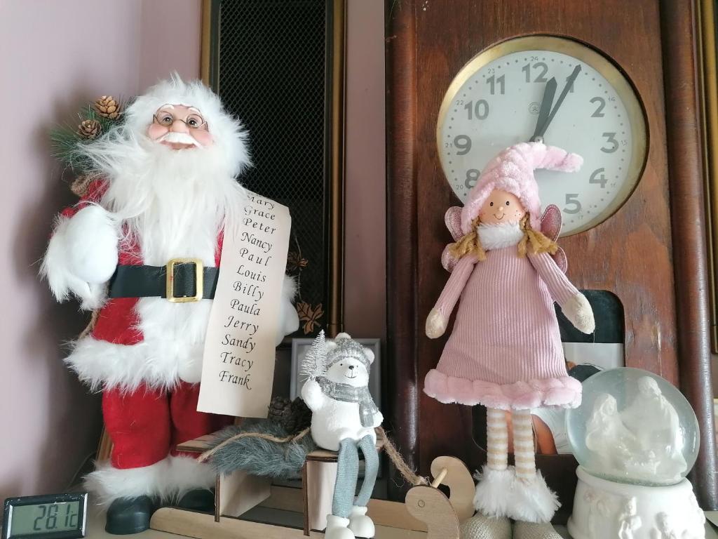 Un grupo de figuritas de Papá Noel junto a un reloj en Willa Na Górce, en Szczyrk
