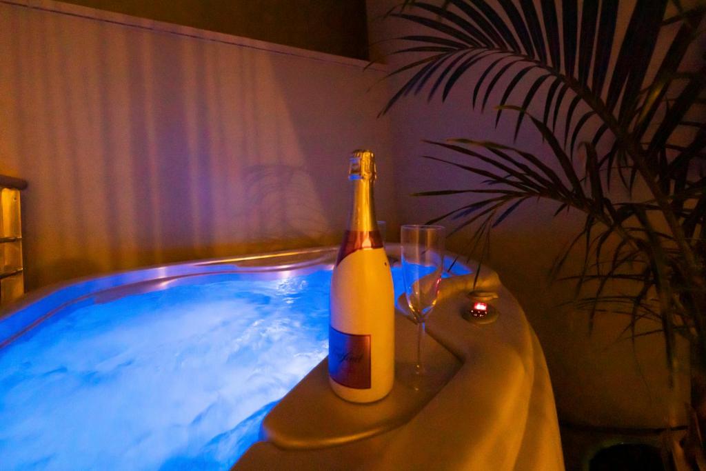 a bottle of beer sitting on a table next to a hot tub at MEDANO4YOU Barefoot Beach House in El Médano