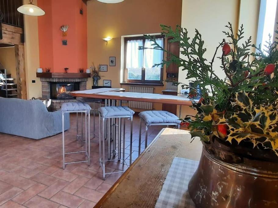 a kitchen with a bar with stools and a fireplace at Cascina Ca' Scarlatta - Your Mountain Holiday in Introbio