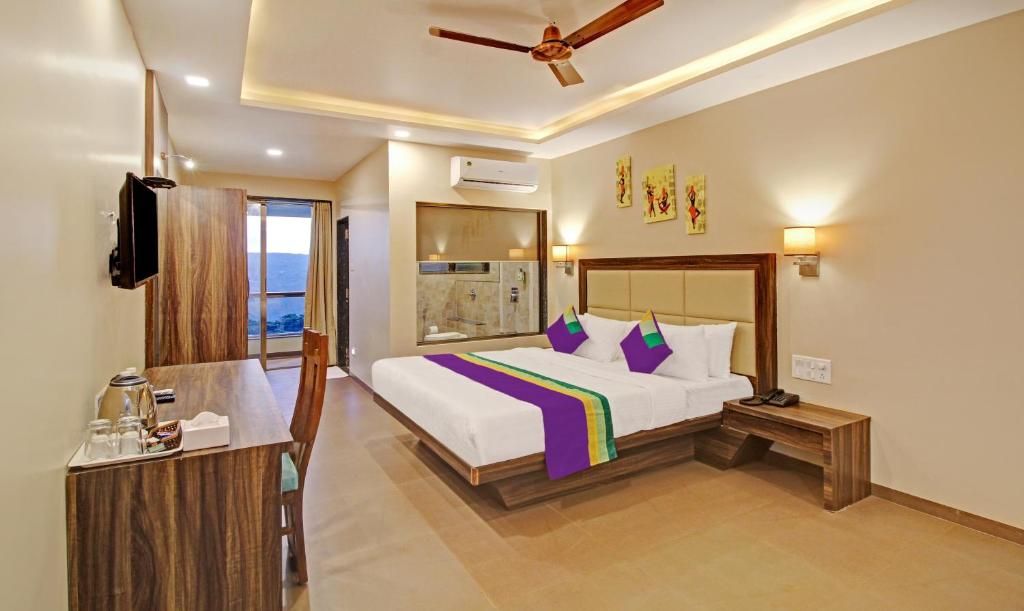 Postel nebo postele na pokoji v ubytování Treebo Mountain Retreat Mahabaleshwar, 600 Mtrs From Lingmala Waterfall