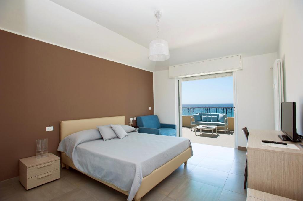 a bedroom with a bed and a television and a balcony at B&B Ligure Rooms in Pietra Ligure