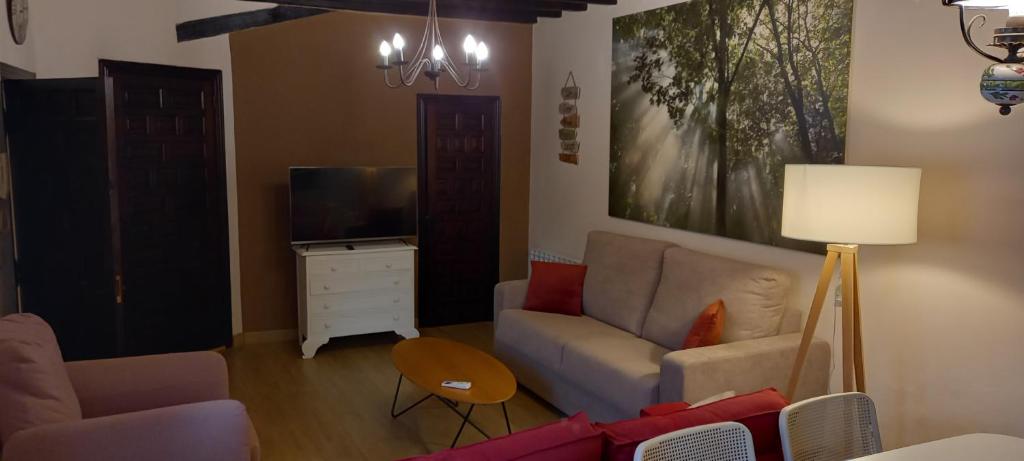 uma sala de estar com um sofá e uma televisão em Casas Recuero em Chinchón