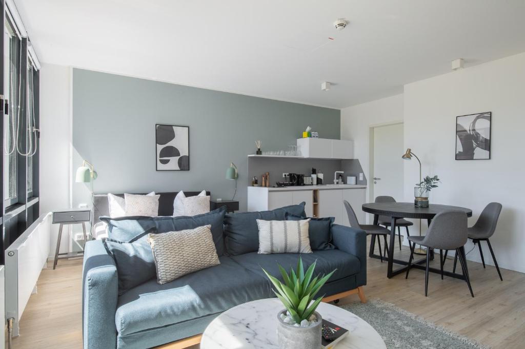 uma sala de estar com um sofá azul e uma mesa em limehome Flensburg Holm em Flensburg
