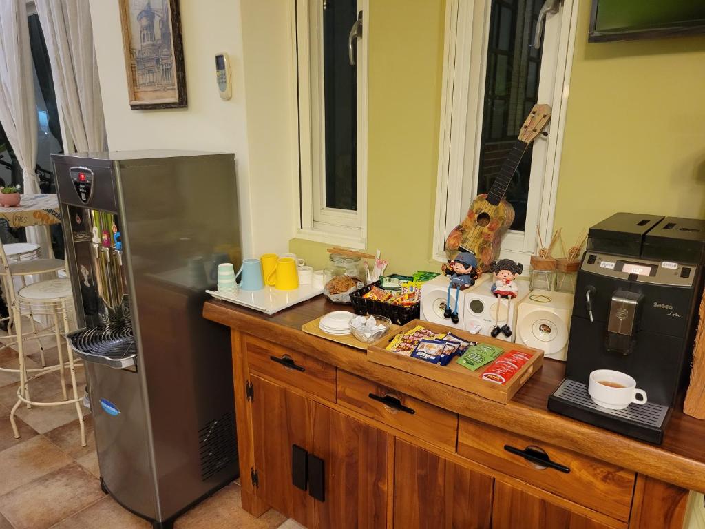 a kitchen with a counter with a refrigerator and a microwave at Slowly B&amp;B in Taitung City