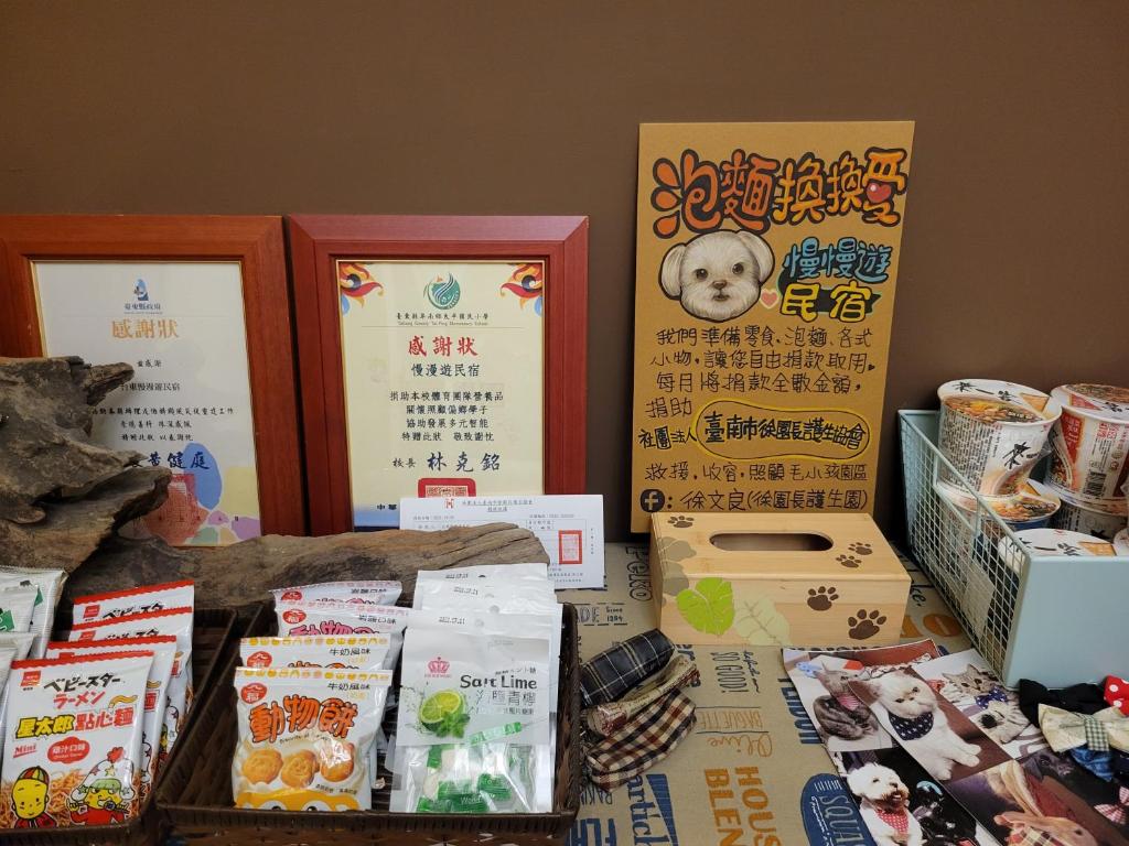 a table topped with boxes of food and signs at Slowly B&amp;B in Taitung City