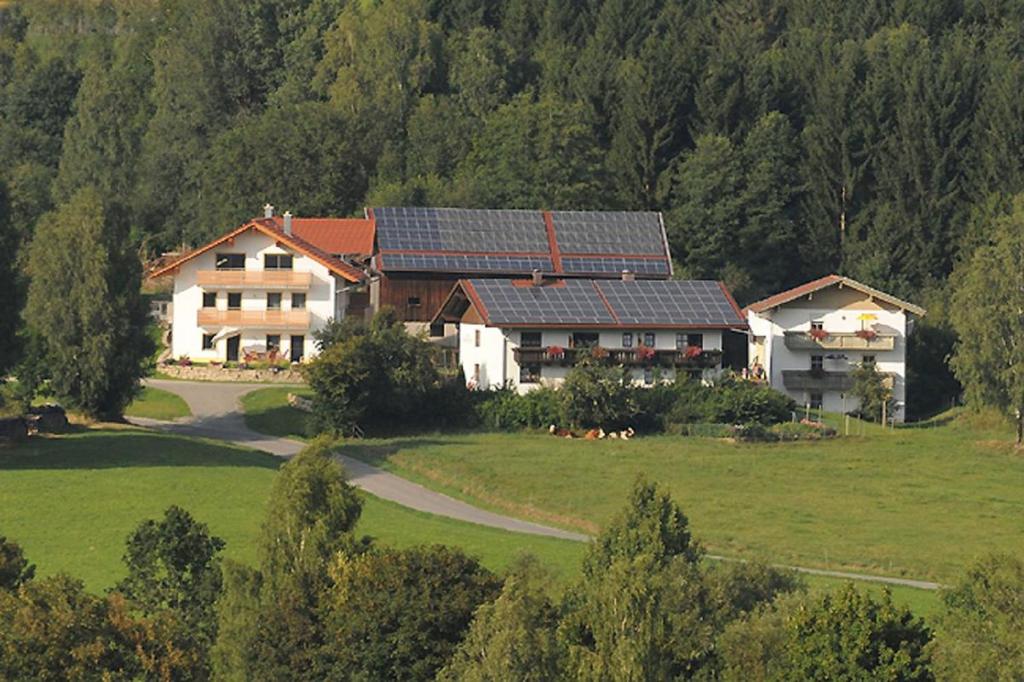 una casa con pannelli solari sul tetto in un campo di Exenbacher Hof - Pension ad Arnbruck