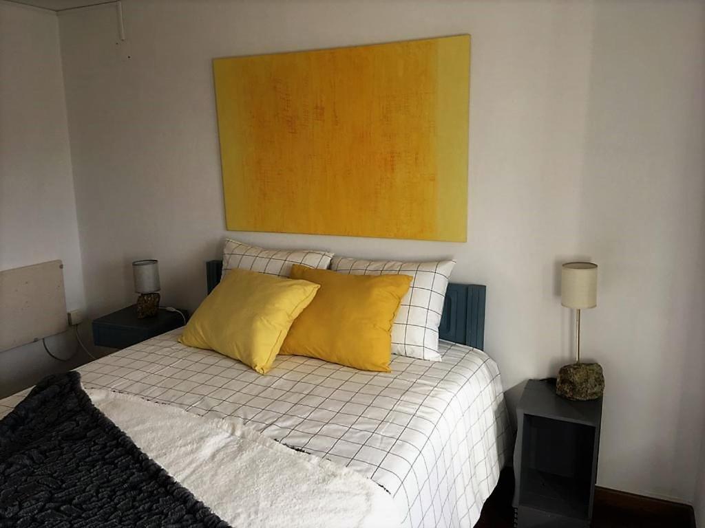 um quarto com uma cama com almofadas amarelas em King Garfield House - Espaço de charme em Bragança em Brangança