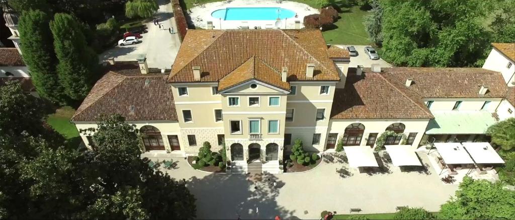 an aerial view of a large house with a pool at Best Western Plus Hotel Villa Tacchi in Gazzo