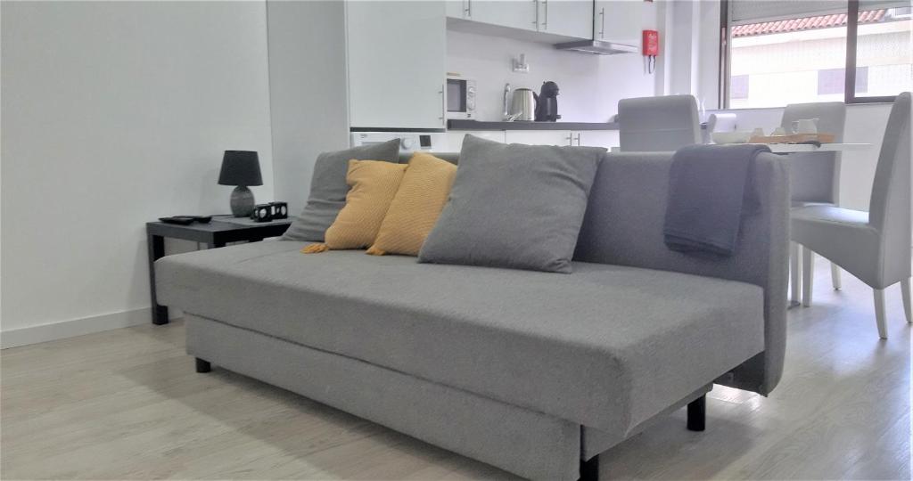 - un canapé avec des oreillers dans le salon dans l'établissement LOFT FORUM BRAGA 1, à Braga