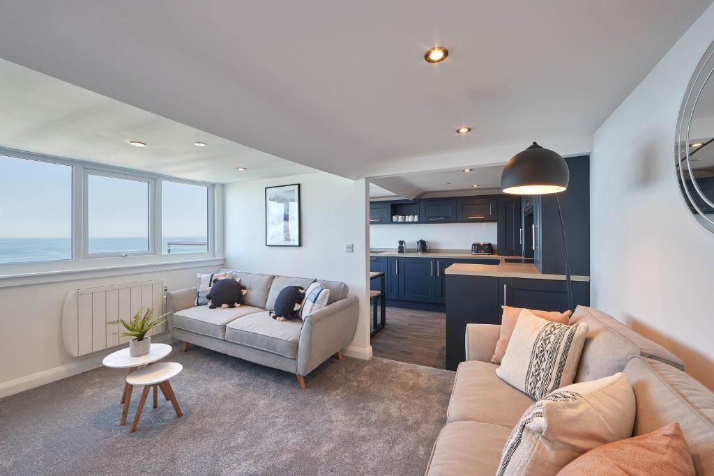 a living room with a couch and a kitchen at Host & Stay - Penthouse Pier View in Whitby