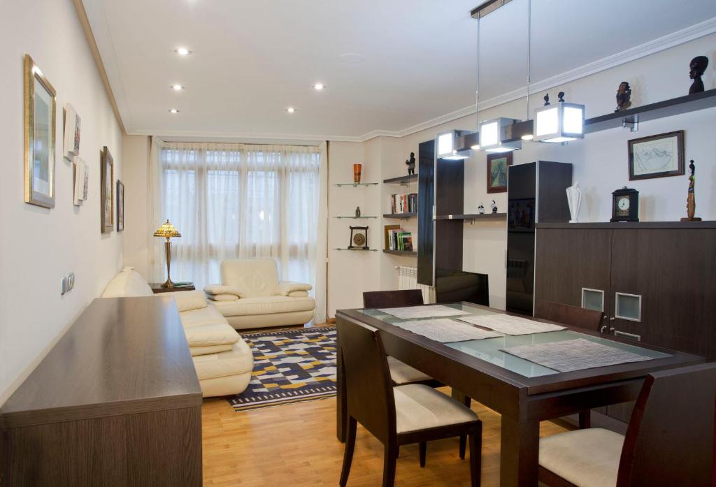 un soggiorno con tavolo da pranzo e un soggiorno con divano. di Apartamento de La Casona de Riomera a Oviedo