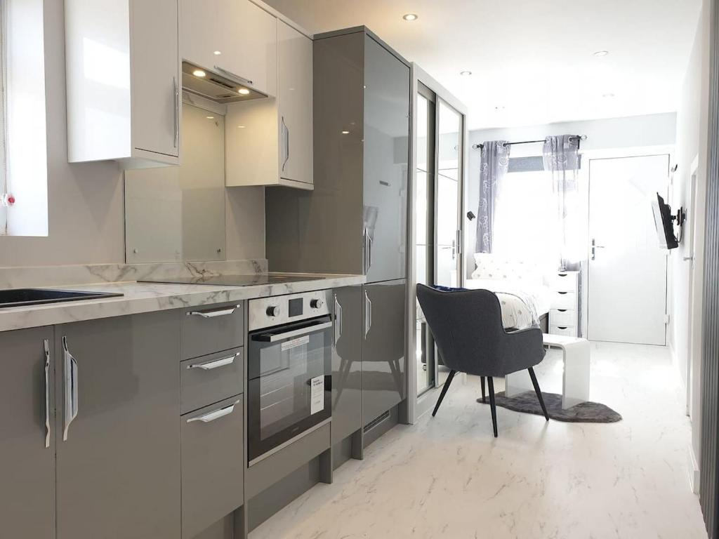 a kitchen with a stove and a chair in it at Modern Studio apartment in Newcastle upon Tyne in Newcastle upon Tyne
