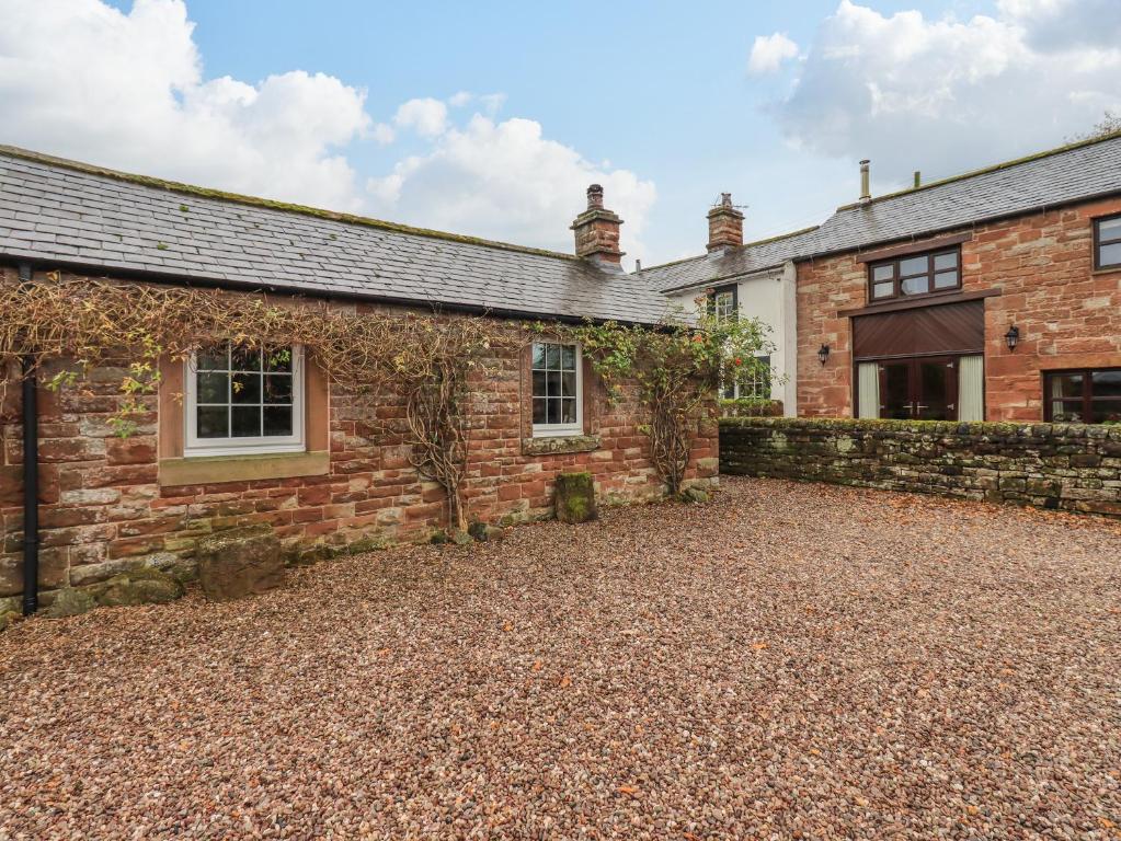 una vista exterior de una casa de ladrillo con entrada de grava en The Cobbles, en Penrith