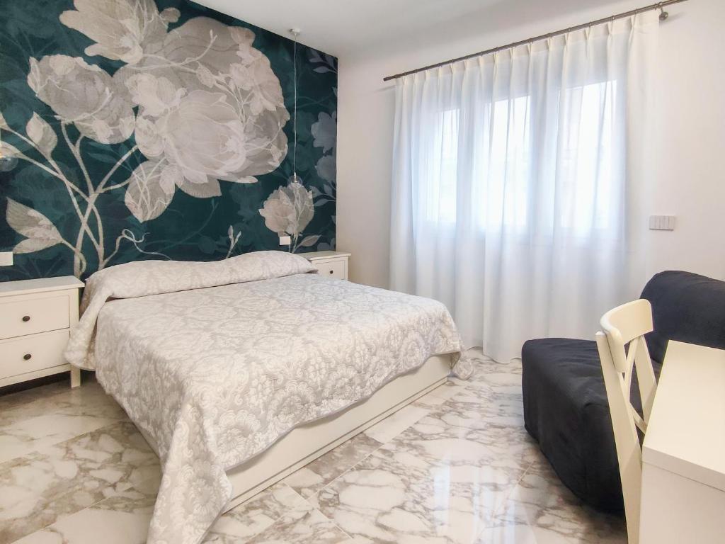 Schlafzimmer mit einem Bett und Blumentapete in der Unterkunft Cubacalatafimi Rooms in Palermo
