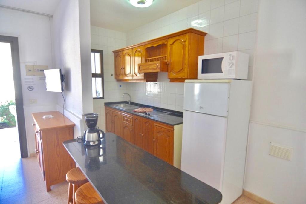 una cucina con frigorifero bianco e armadietti in legno di Comfortable Apartment in Puerto Rico a Mogán