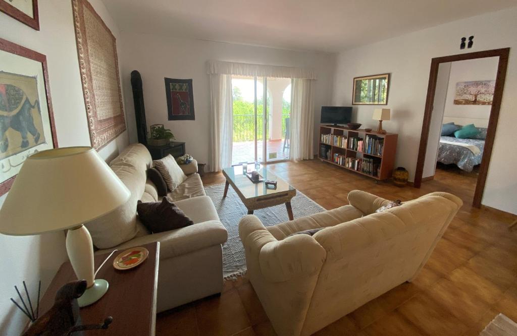 uma sala de estar com dois sofás brancos e uma mesa em Casa Zawadi em Mijas