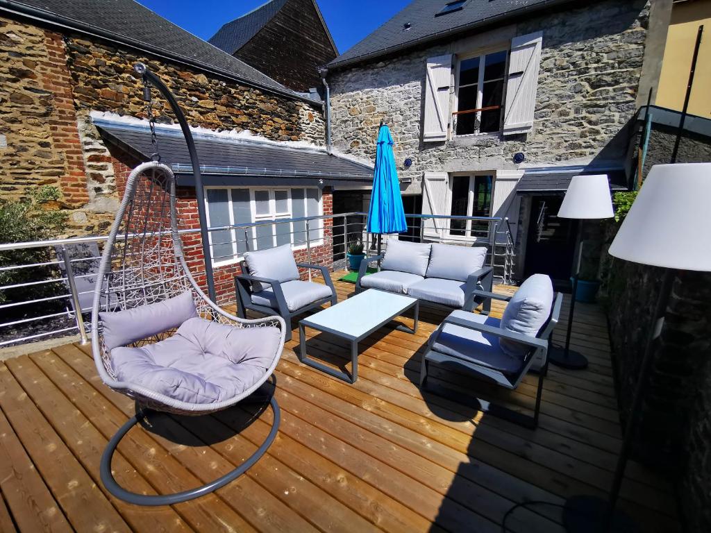 een veranda met een hangmat en stoelen op een terras bij La Bayenne in Revin