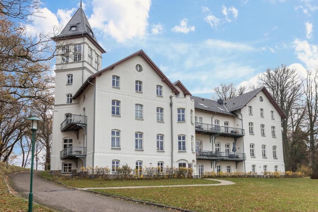 a large white building with a clock tower at Jagdschloß zu Hohen Niendorf in Hohen Niendorf