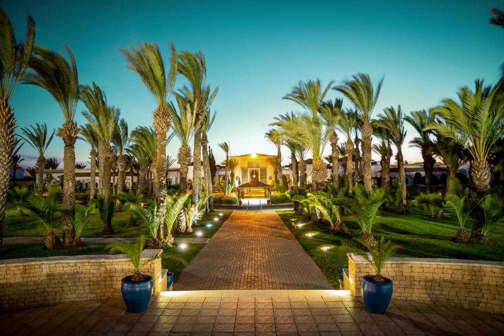 un camino que conduce a una casa con palmeras y luces en ROBINSON AGADIR - All Inclusive, en Agadir