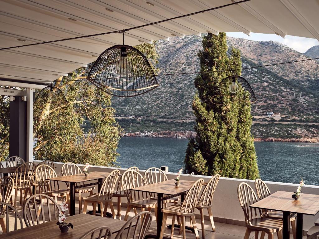 a row of tables and chairs with a view of the water at Troulis Apart-Hotel in Balíon