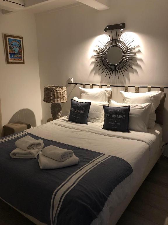 a bedroom with a large bed with a mirror on the wall at Maxima Sunset in Sainte-Maxime