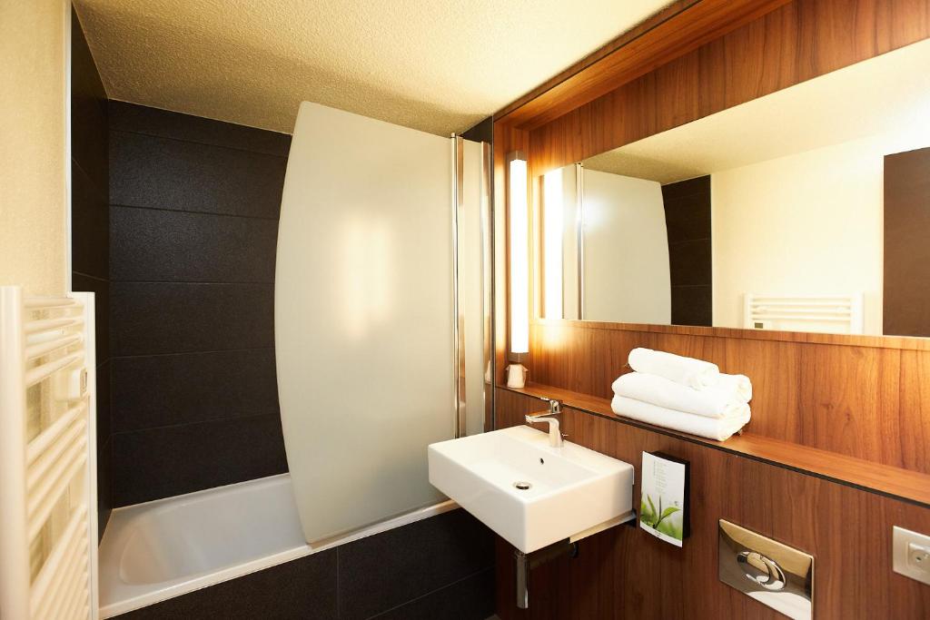 a bathroom with a sink and a mirror at Campanile Pau Est-Bizanos in Pau