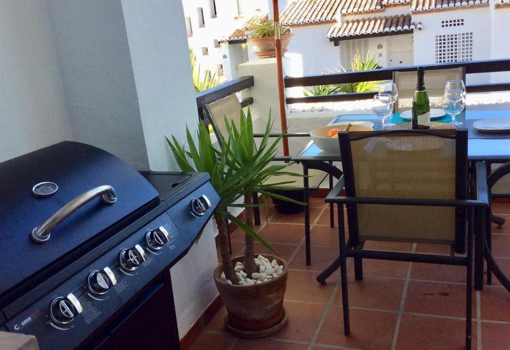 eine Küche mit einem Herd und einem Tisch mit einem Stuhl in der Unterkunft Vista Marina - 2 bedrooms sleeps 4 in La Herradura