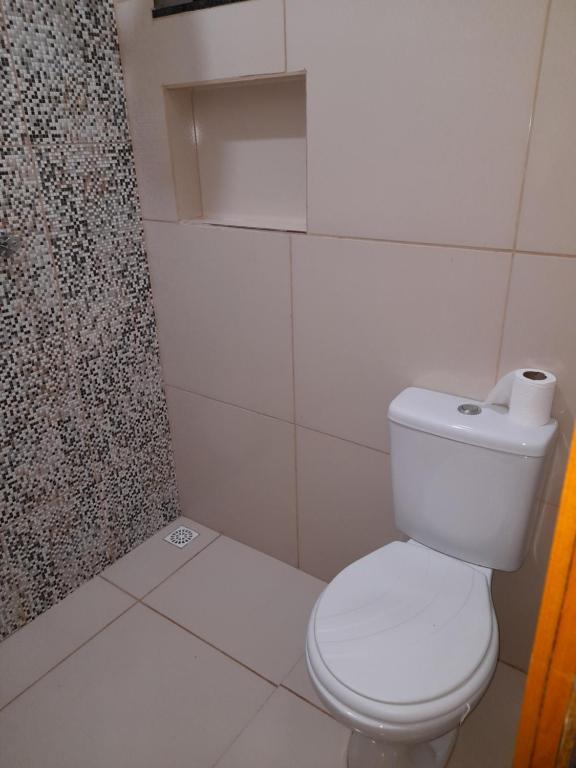 a white bathroom with a toilet and a shower at Casa Serrana beach Camocim in Camocim