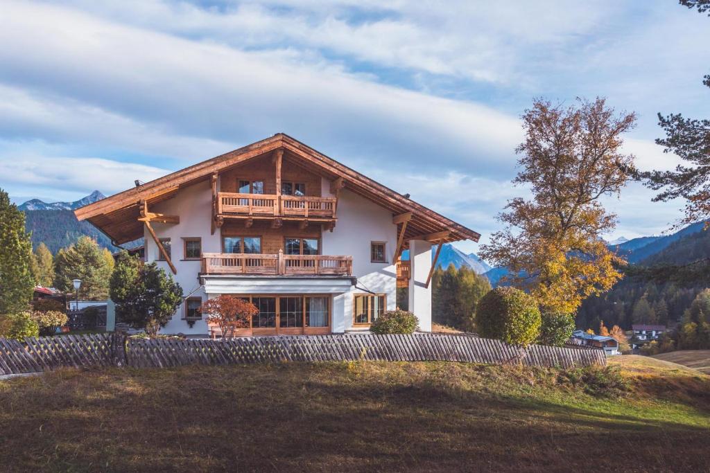 uma casa grande com uma varanda no topo de um quintal em Appartement SEEFELDER SPITZE by MoniCare em Seefeld no Tirol