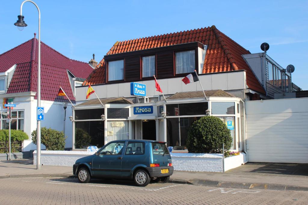 un pequeño coche aparcado frente a un edificio en Hotel Arosa, en Zandvoort